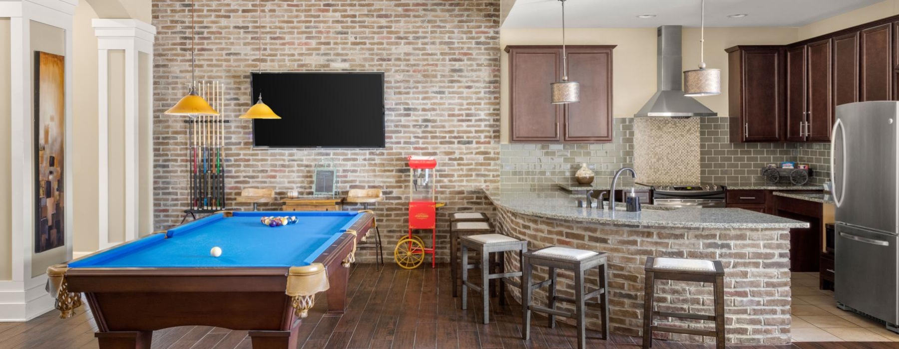 a large kitchen with a pool table and tv