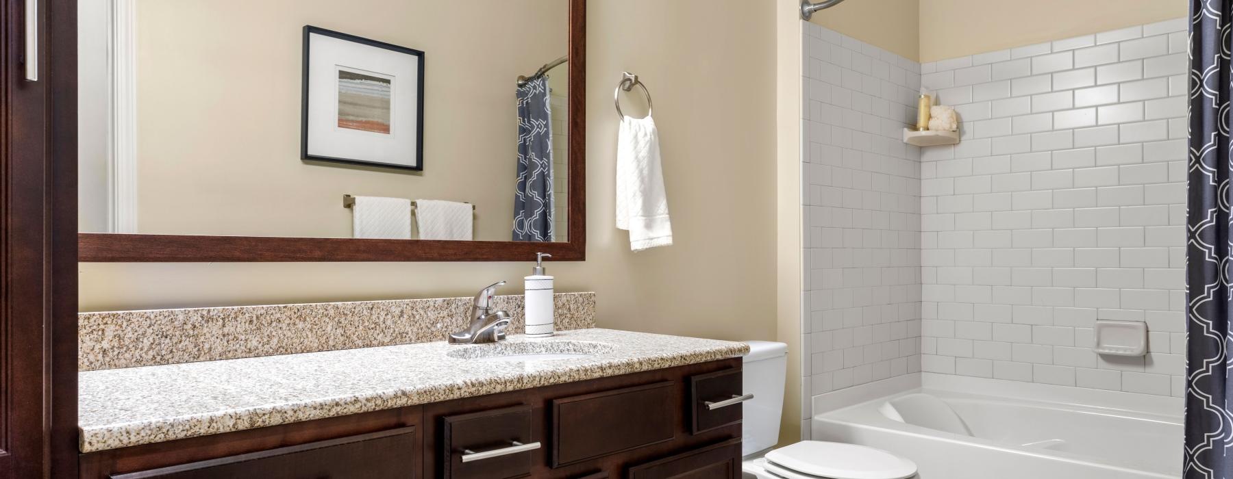 a bathroom with a large mirror toilet and tub