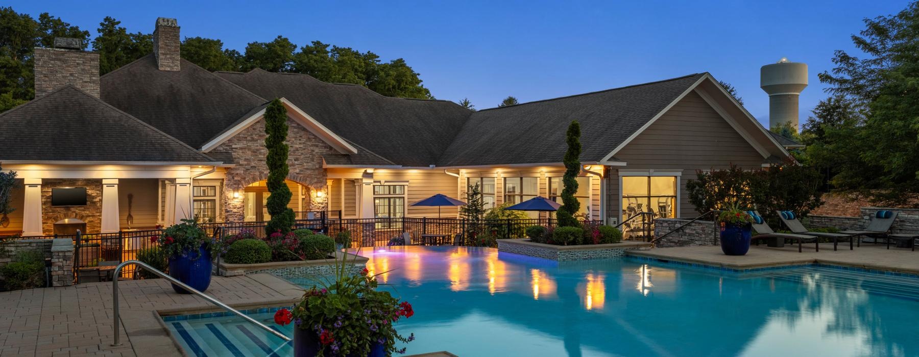 resort style pool with a building behind it at dusk