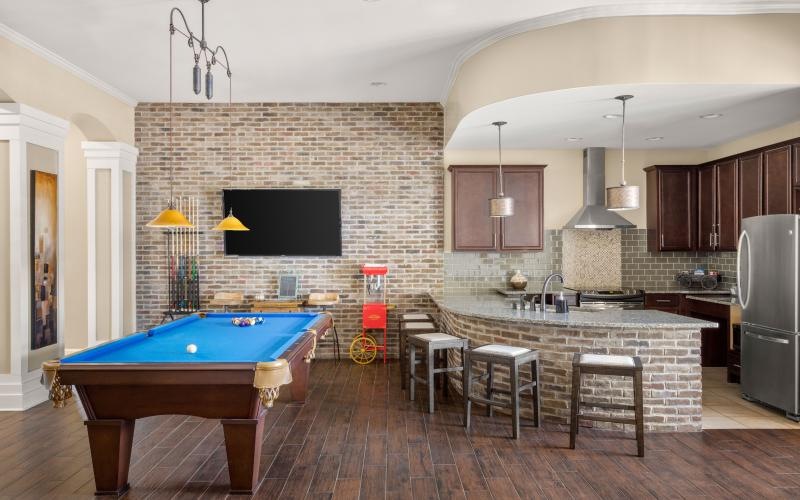 a large kitchen with a pool table and tv