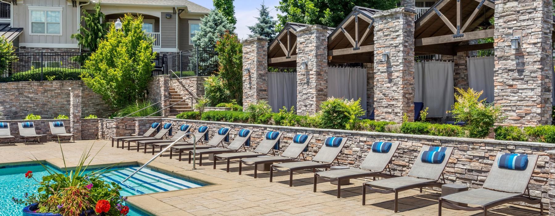 a patio with pool chairs and tables